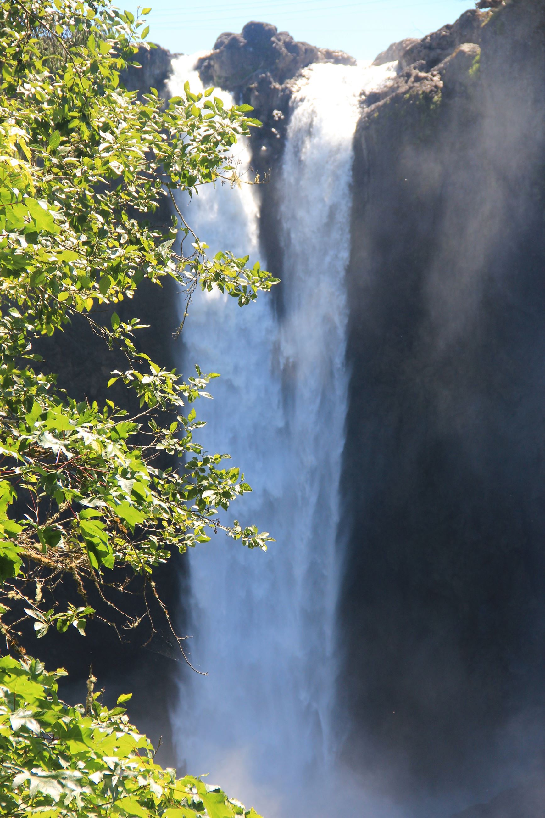 Waterfall cascading down a rocky cliff with greenery